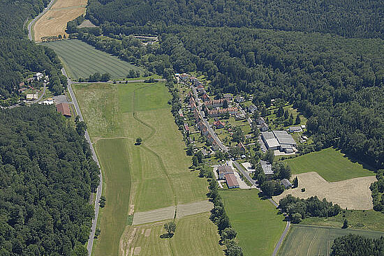 Dorf umgeben von Wald und Wiesen