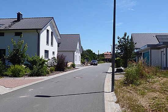 Baugebiet Bahnhofstrasse mit Häusern, Laterne und Grünflächen
